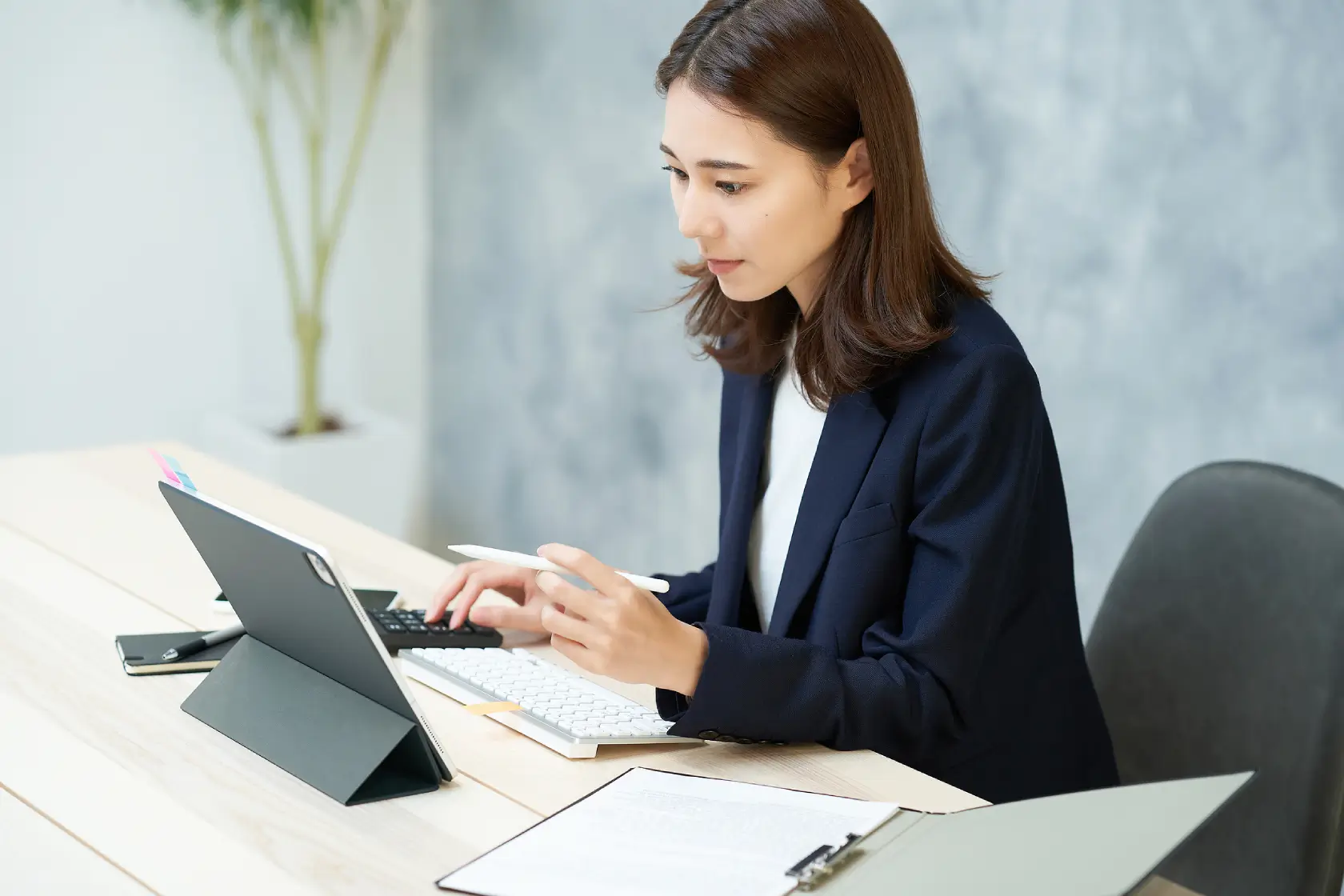 Woman working on tablet and keyboard
