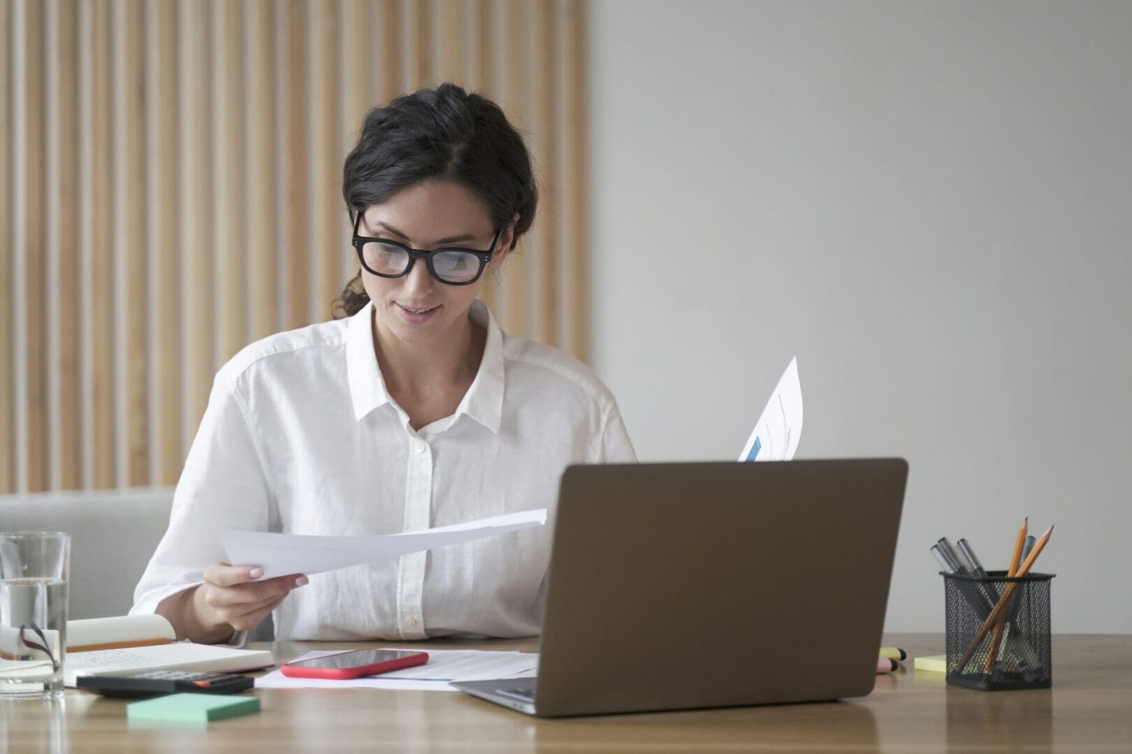 Woman reading documents at a desk.